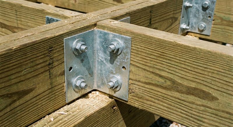 Galvanized deck framing hardware and hurricane ties on pressure-treated joists