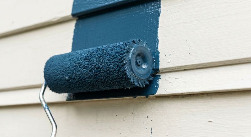 Premium exterior paint rolled onto primed clapboard siding