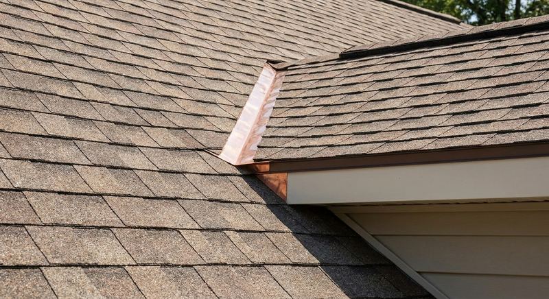 Addition roofline meeting existing roof with matched shingles and flashing