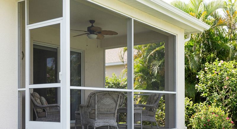 Screened lanai with ceiling fan and wicker seating on a Florida home